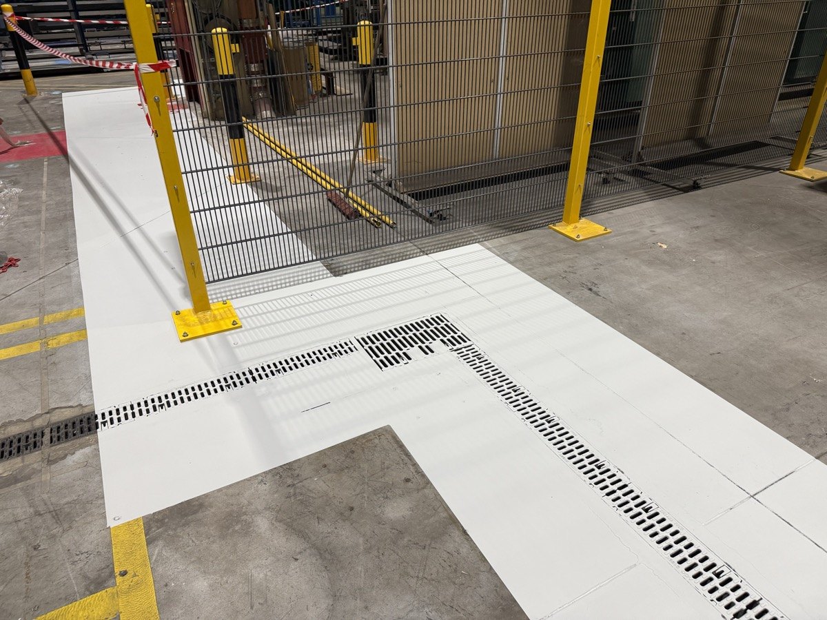 White floor coating beside a machine enclosure